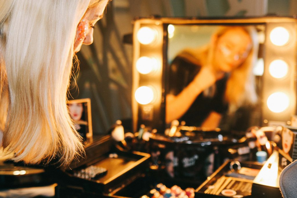 A girl applying GlitterLips at the Twins That Travel Sandals Blogging Event