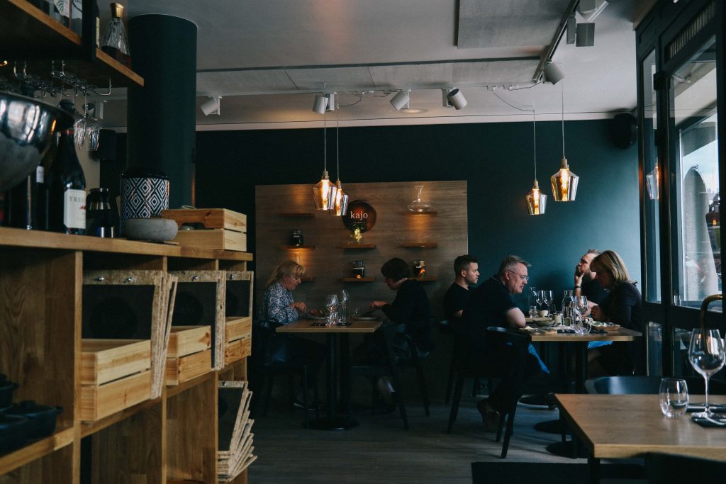 The interior of Kajo restaurant, featuring hung lighting and tables of diners.