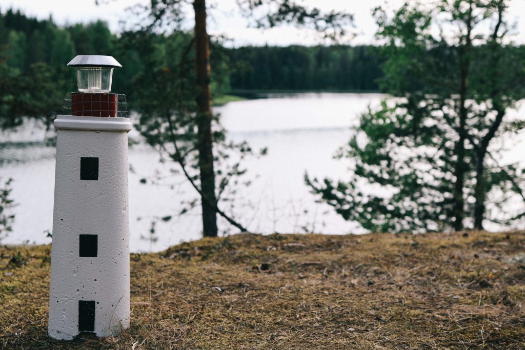 A small statue of a lighthouse overlooking a Finnish lake in Tampere.