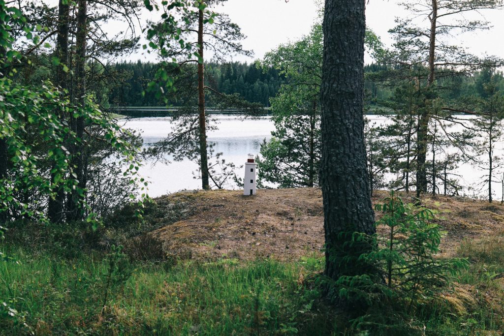 A small statue of a lighthouse, overlooking a Finnish lake in Tampere.