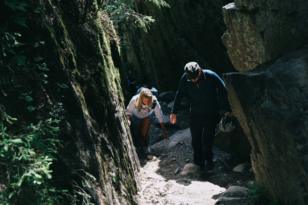 A girl climbing a steep rocky path in Helvetinjärvi National Park.